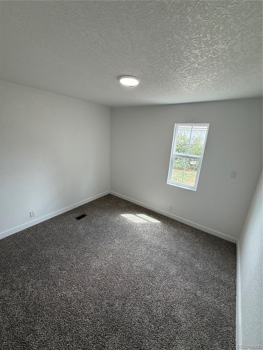 1045 Mac Davidson Circle Dacono, CO 80514 - Photo 27 of 32 an empty room with windows