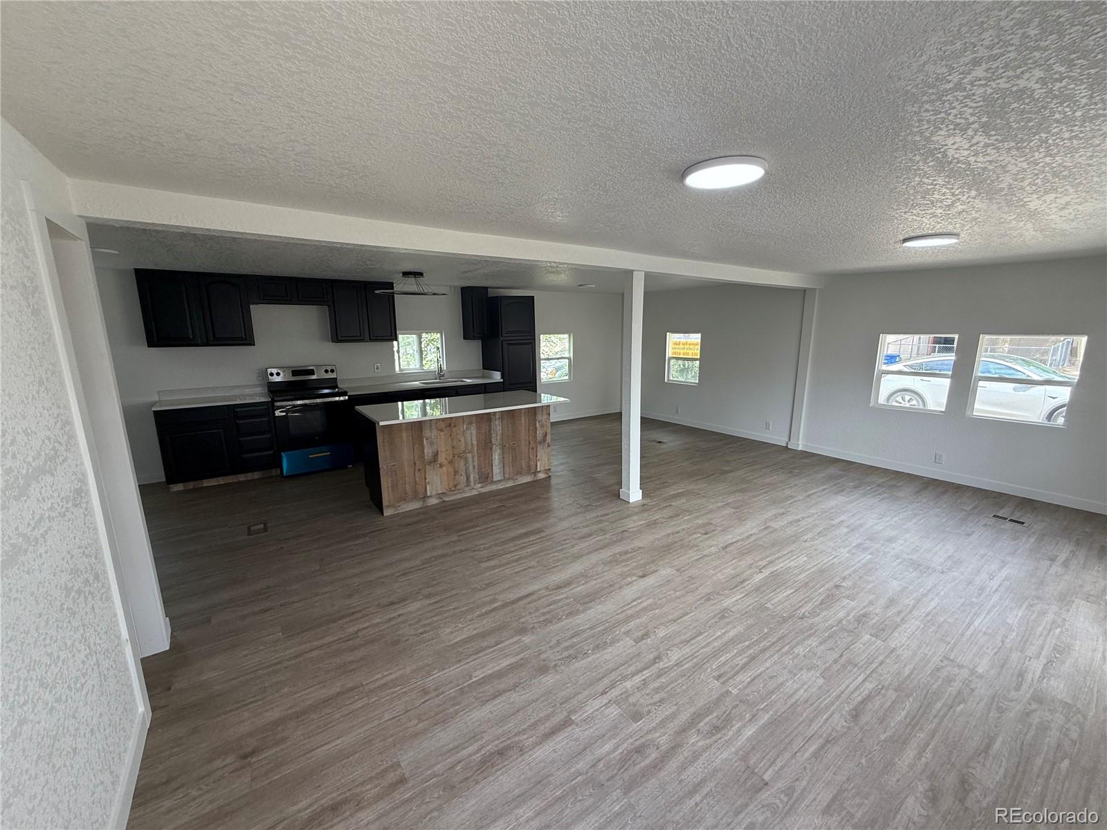 1045 Mac Davidson Circle Dacono, CO 80514 - Photo 30 of 32 a kitchen with stainless steel appliances granite countertop a stove and a wooden floors