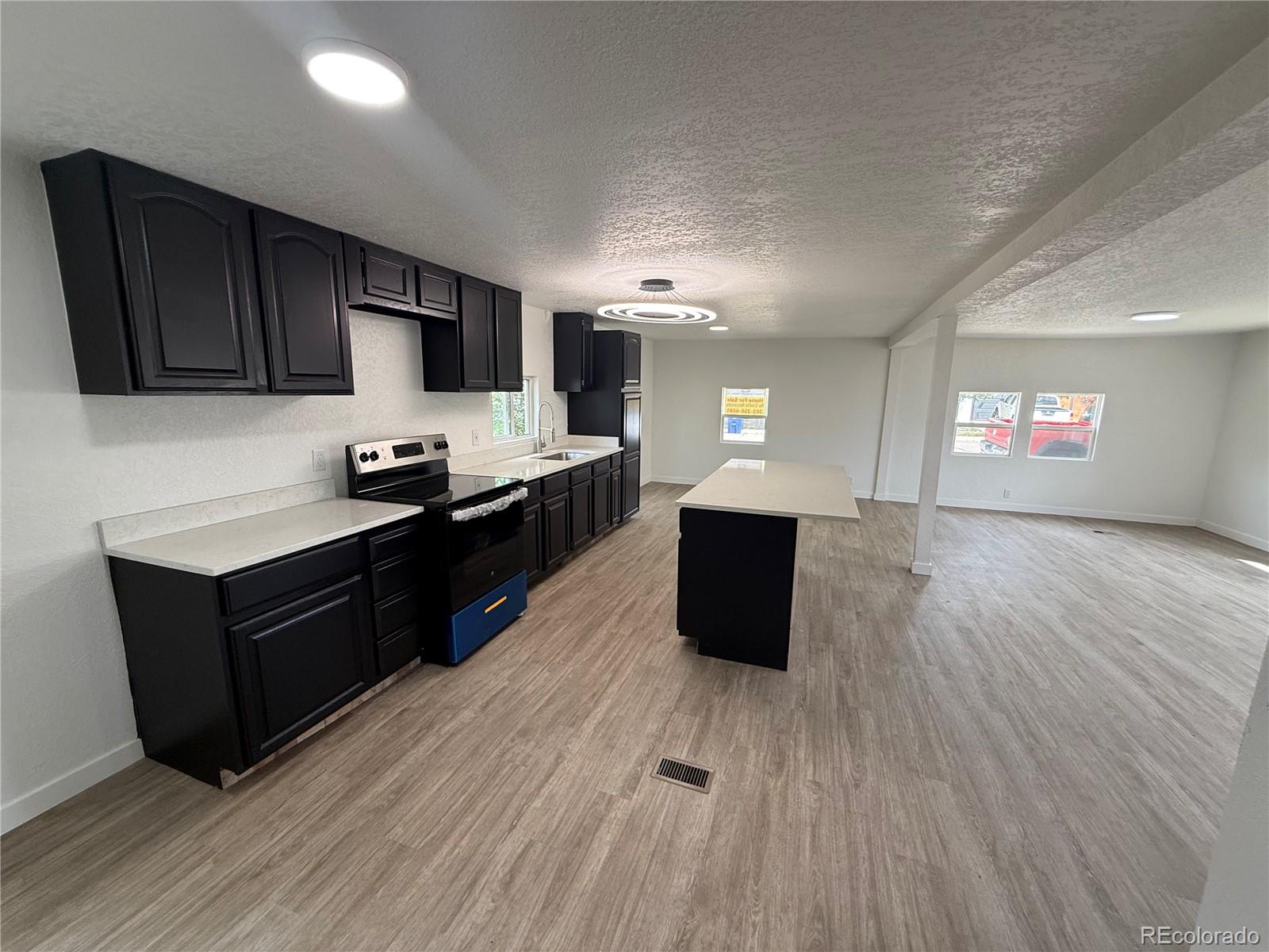 1045 Mac Davidson Circle Dacono, CO 80514 - Photo 3 of 32 a kitchen with granite countertop a sink and a stove top oven