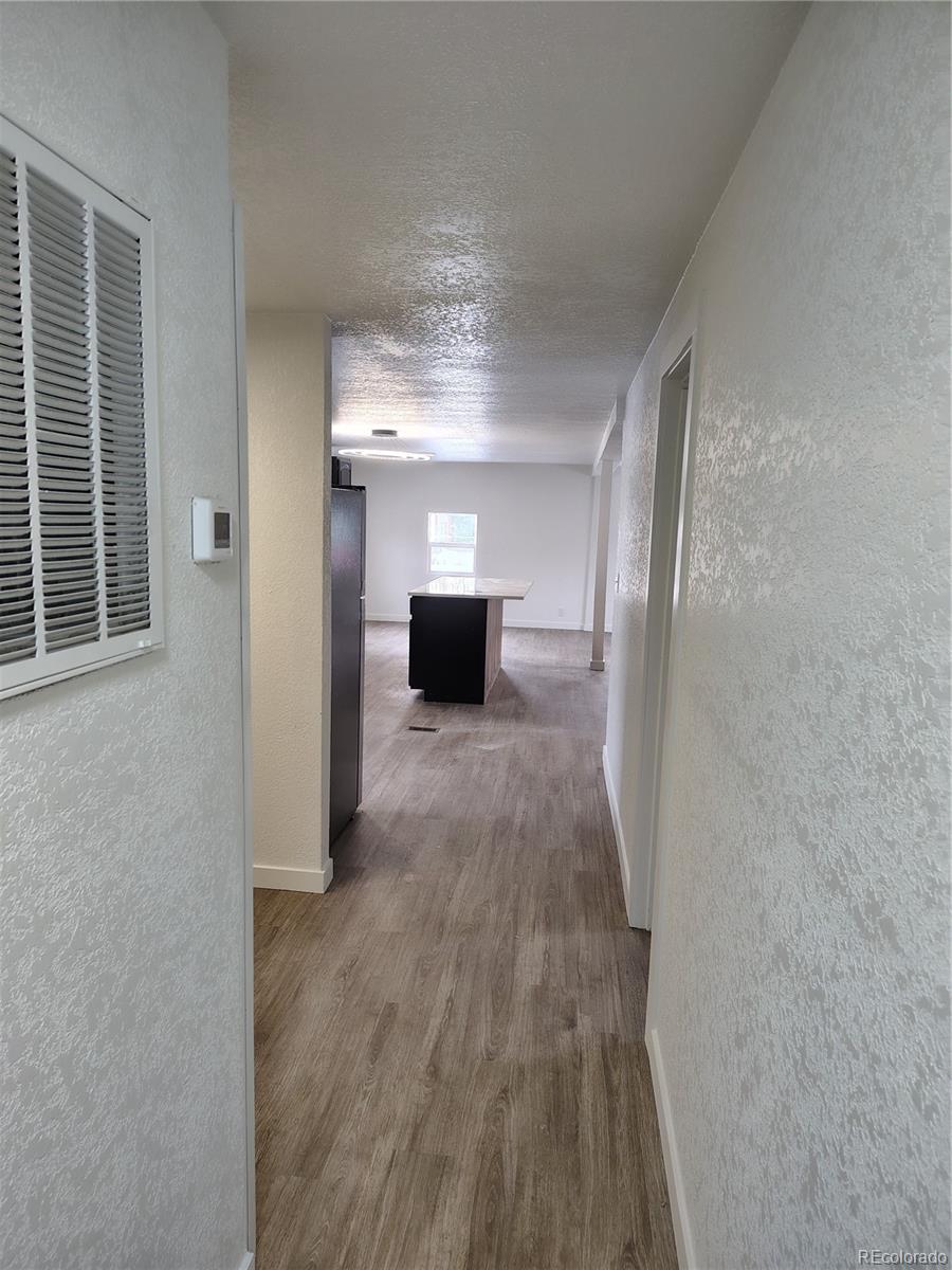 1045 Mac Davidson Circle Dacono, CO 80514 - Photo 4 of 32 a view of a room with wooden floor a fireplace and window