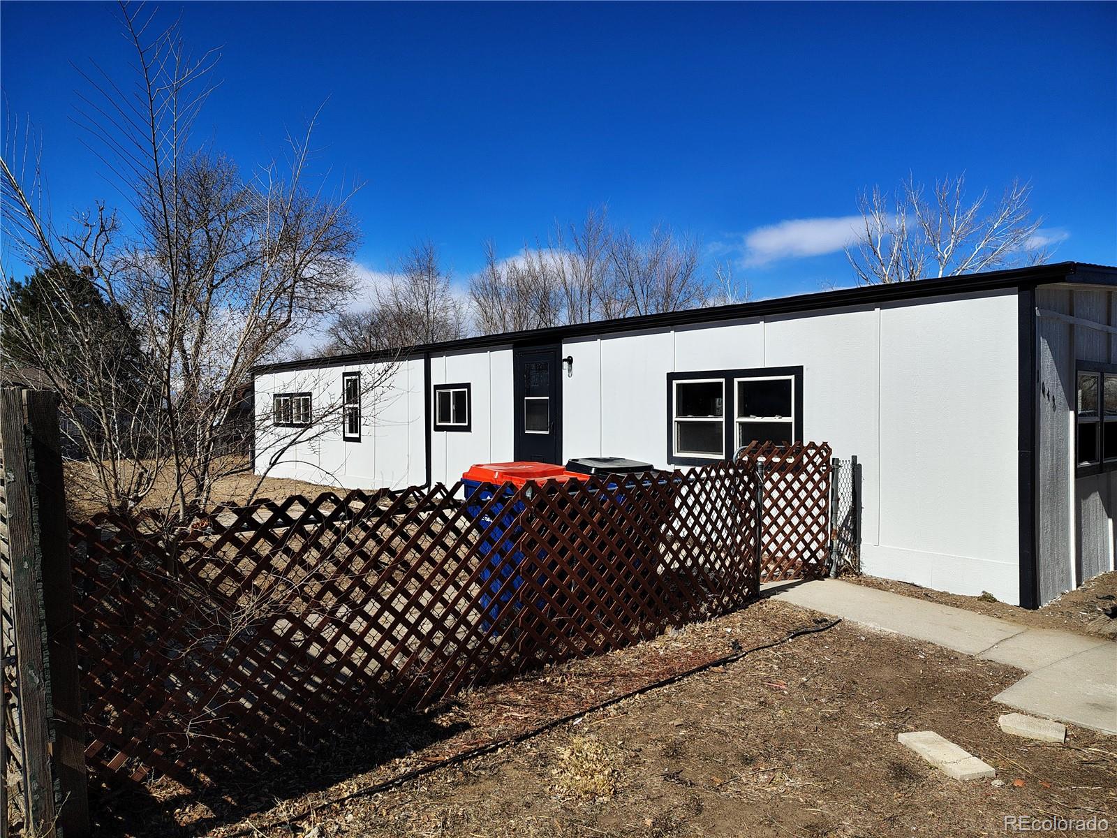 1045 Mac Davidson Circle Dacono, CO 80514 - Photo 5 of 32 a side view of a house with a yard