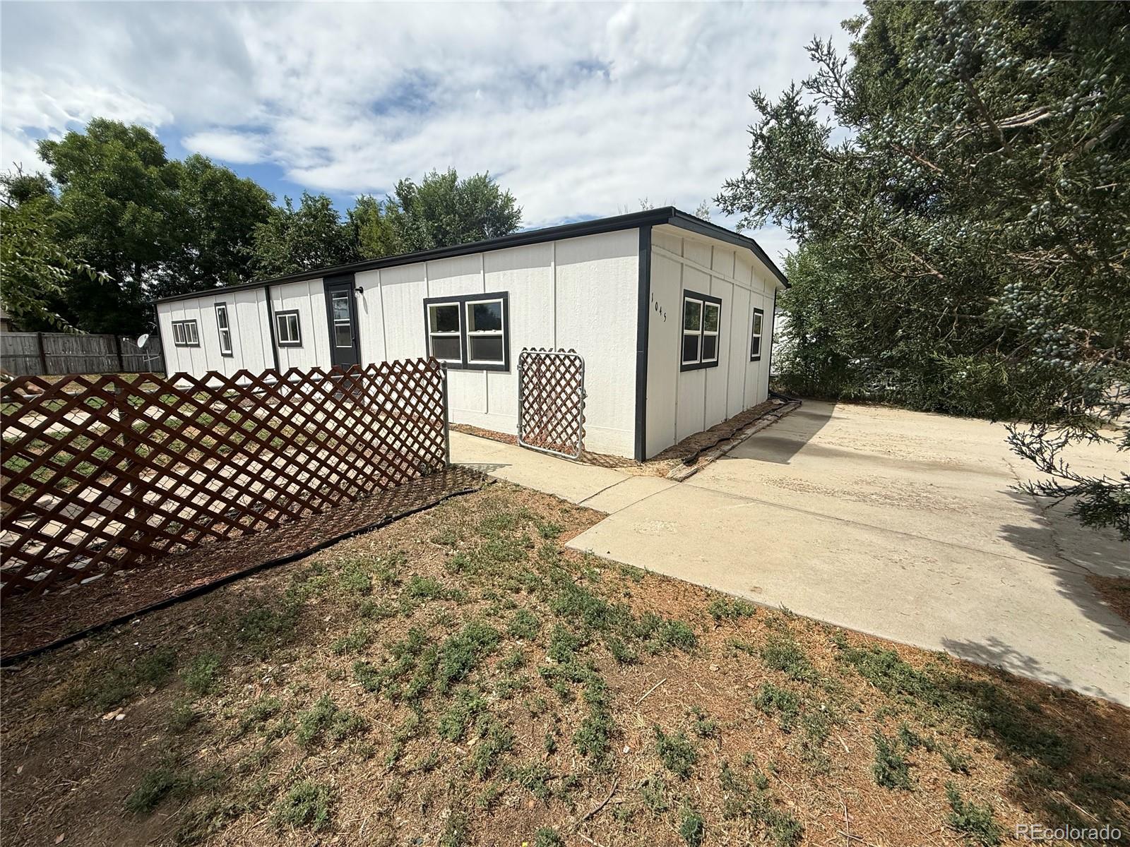 1045 Mac Davidson Circle Dacono, CO 80514 - Photo 7 of 32 a front view of a house with a yard