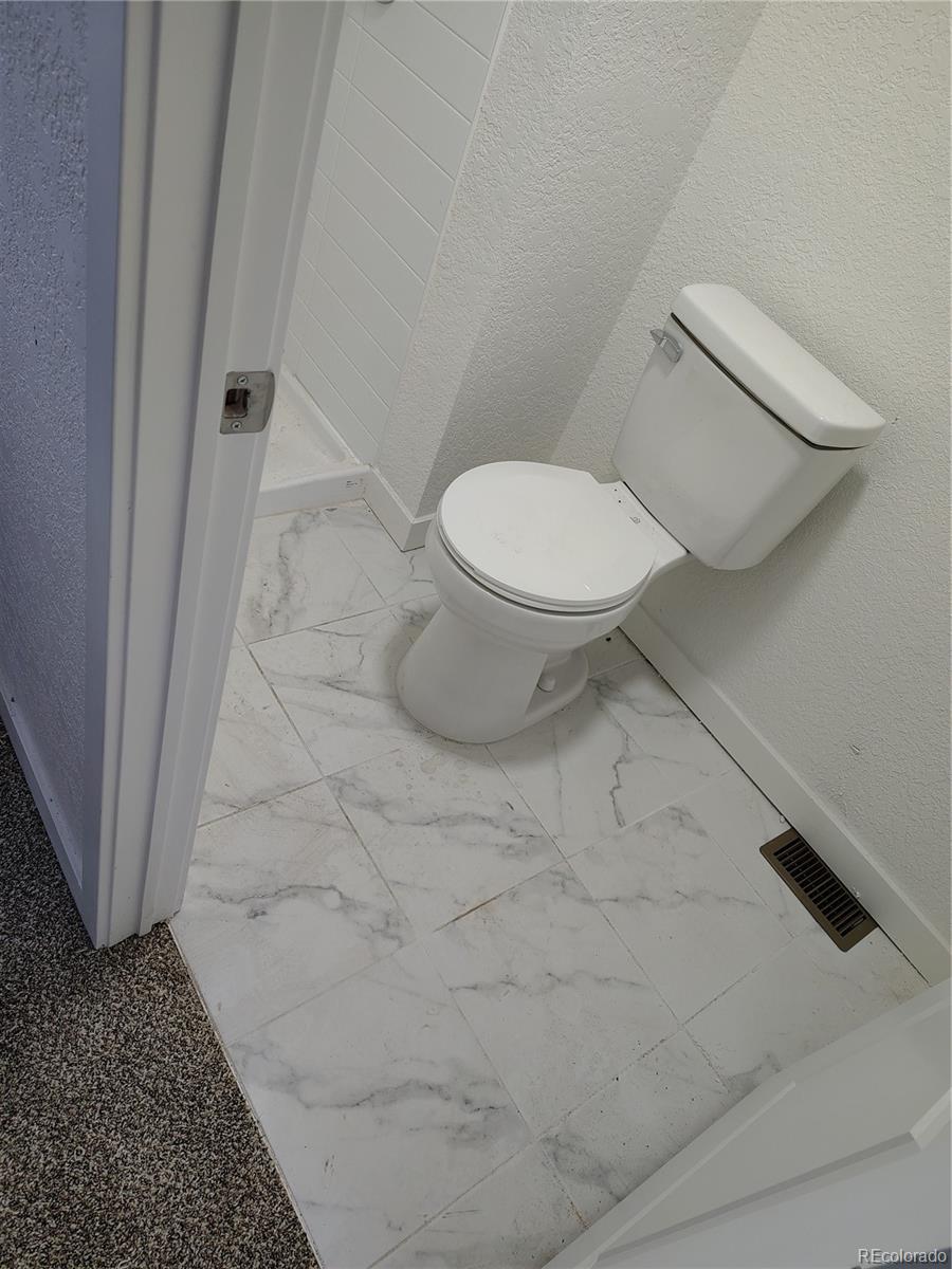 1045 Mac Davidson Circle Dacono, CO 80514 - Photo 8 of 32 a bathroom with a toilet and a rug