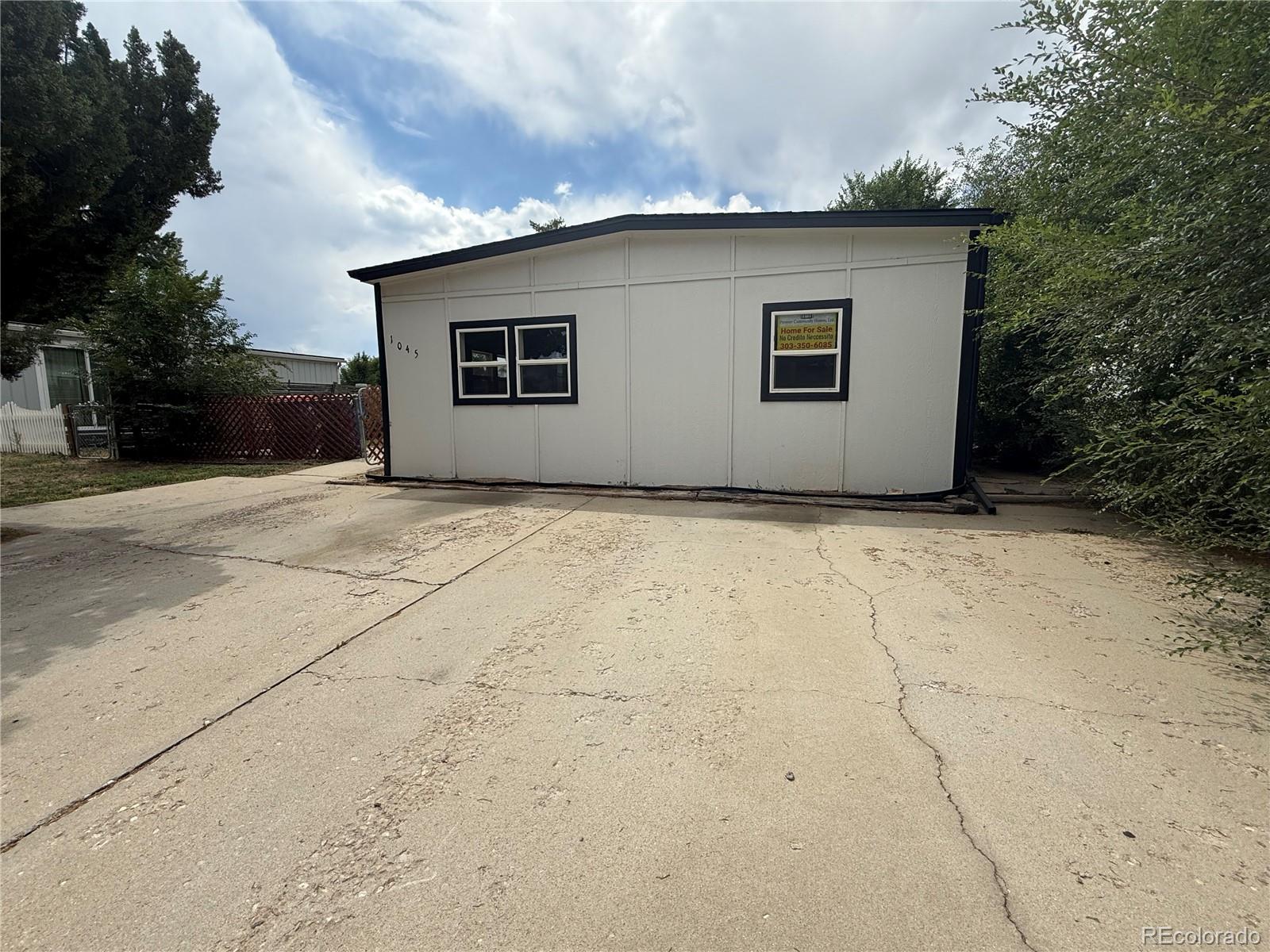 1045 Mac Davidson Circle Dacono, CO 80514 - Photo 10 of 32 a house with trees in front of it