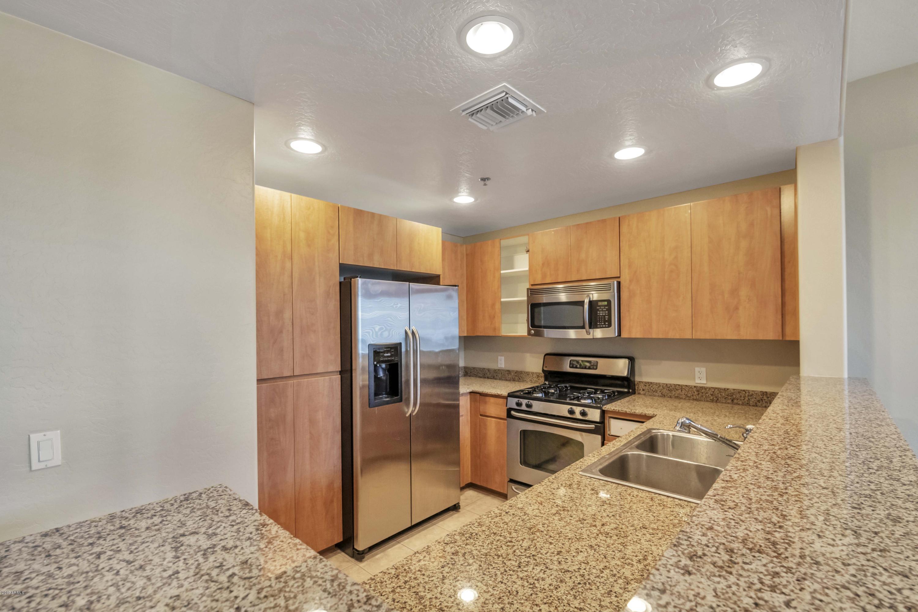 16 West Encanto Boulevard, Unit 615 Phoenix, AZ 85003 - Photo 2 of 33 a kitchen with granite countertop a refrigerator and a sink