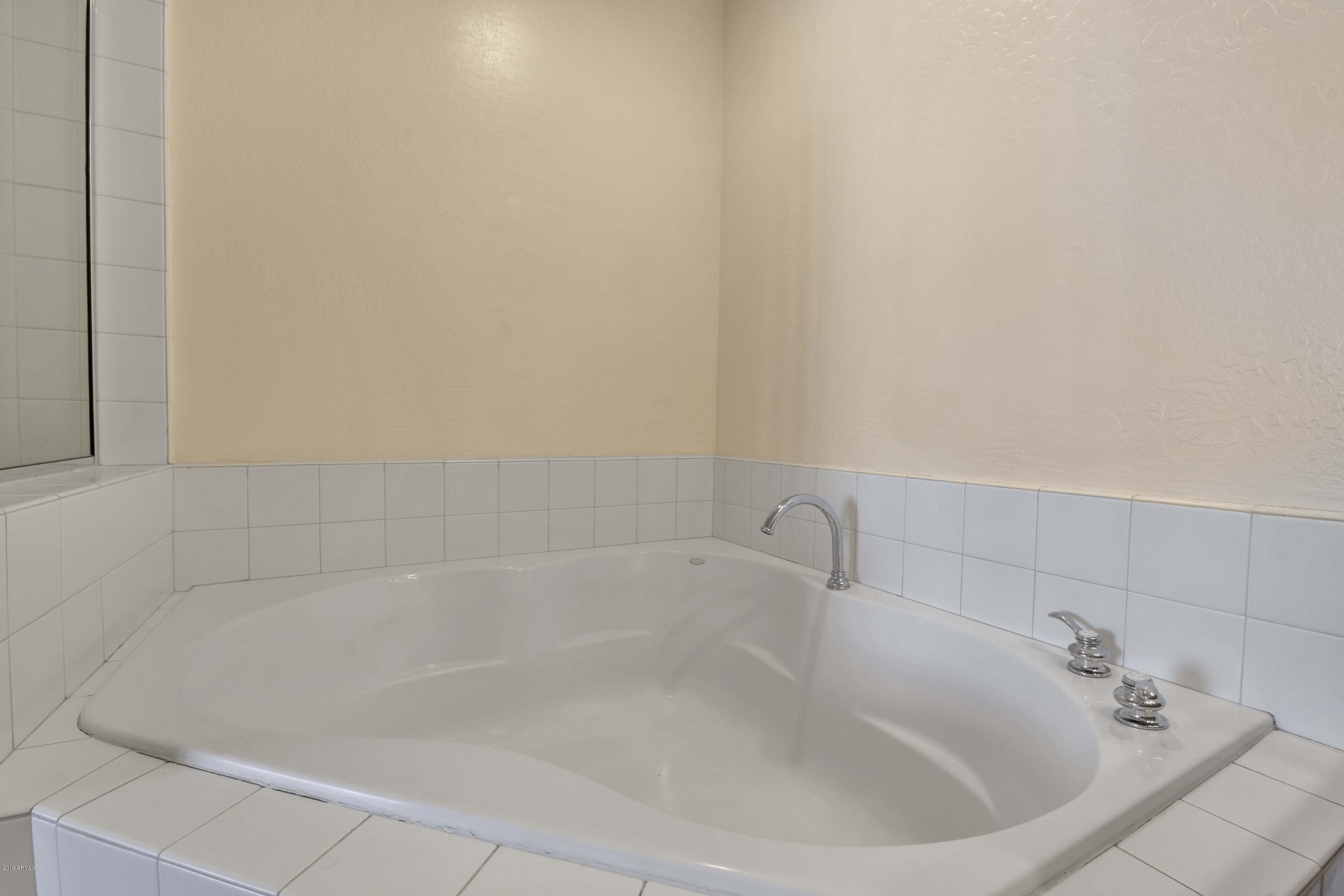 16 West Encanto Boulevard, Unit 615 Phoenix, AZ 85003 - Photo 22 of 33 a white bath tub sitting next to a white sink and vanity