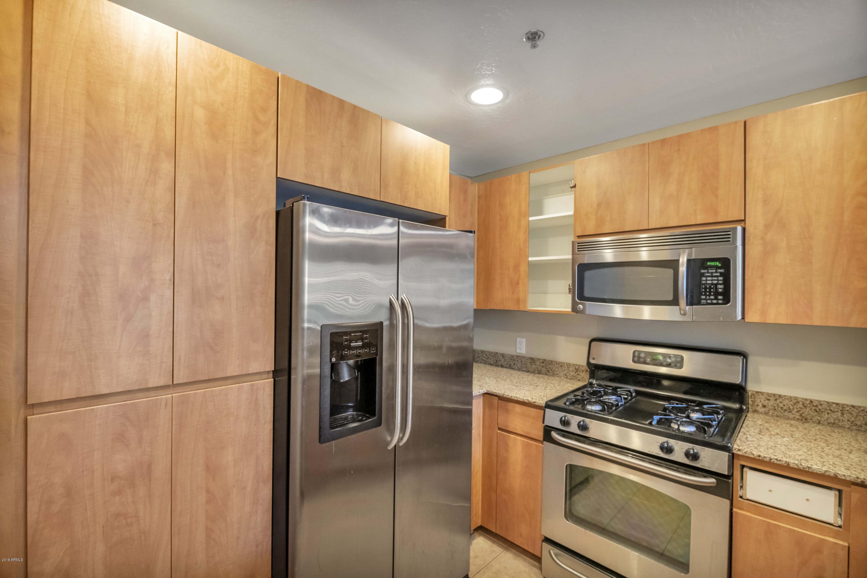 16 West Encanto Boulevard, Unit 615 Phoenix, AZ 85003 - Photo 3 of 33 a kitchen with stainless steel appliances granite countertop a refrigerator stove and microwave