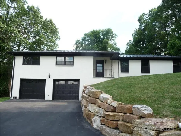 a front view of a house with a garden and yard