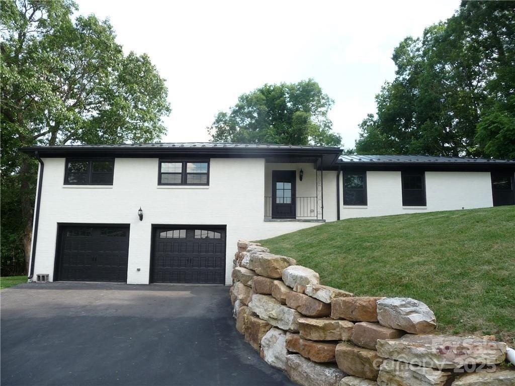 a front view of a house with a garden and yard