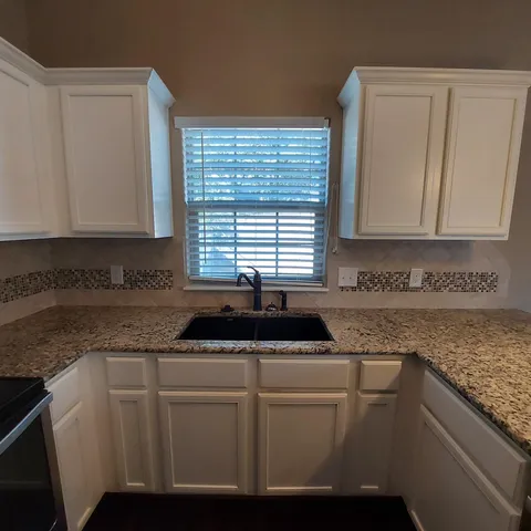 a kitchen with granite countertop stainless steel appliances and wooden cabinets
