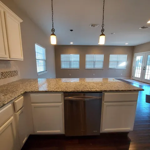 a view of a kitchen with furniture and wooden floor