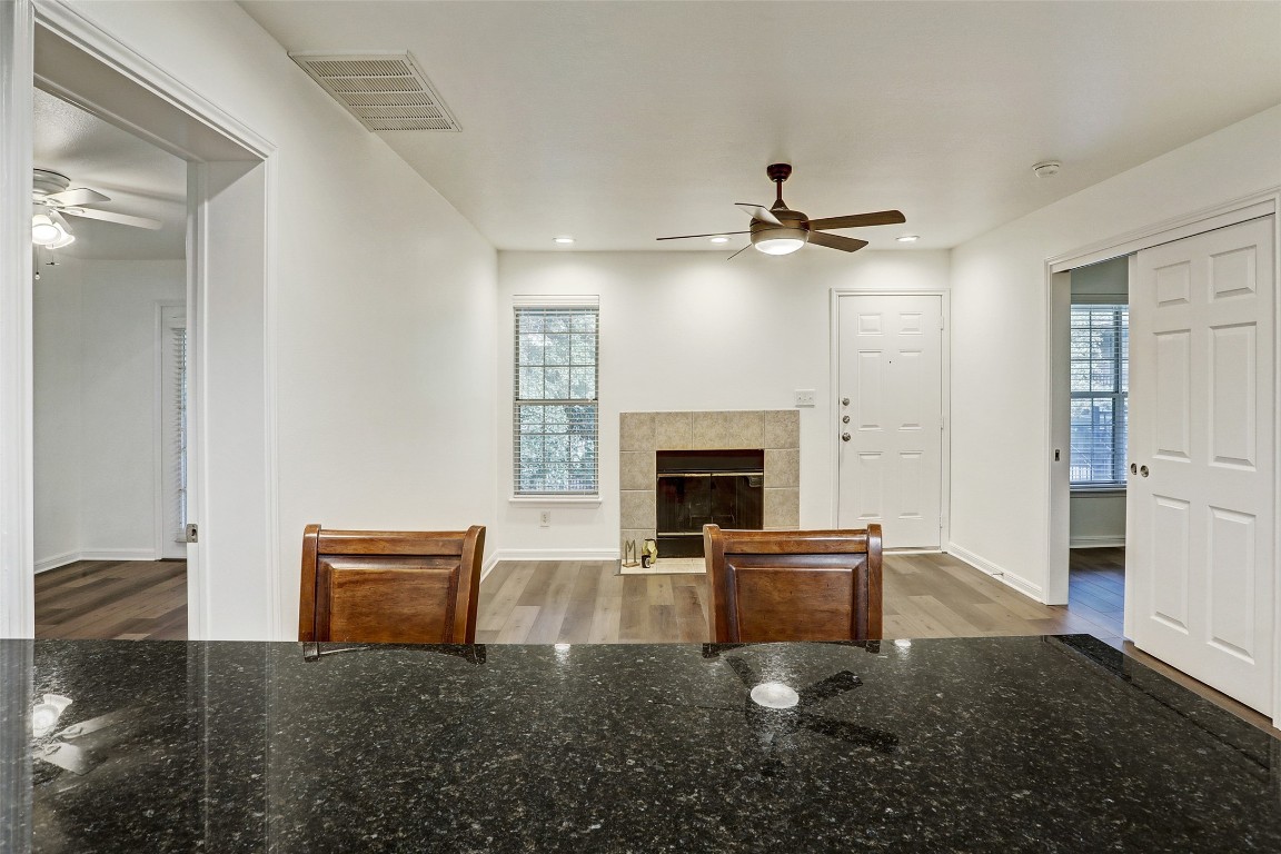 7685 Northcross Drive, Unit 426 Austin, TX 78757 - Photo 10 of 35 a living room with furniture a fireplace and a ceiling fan