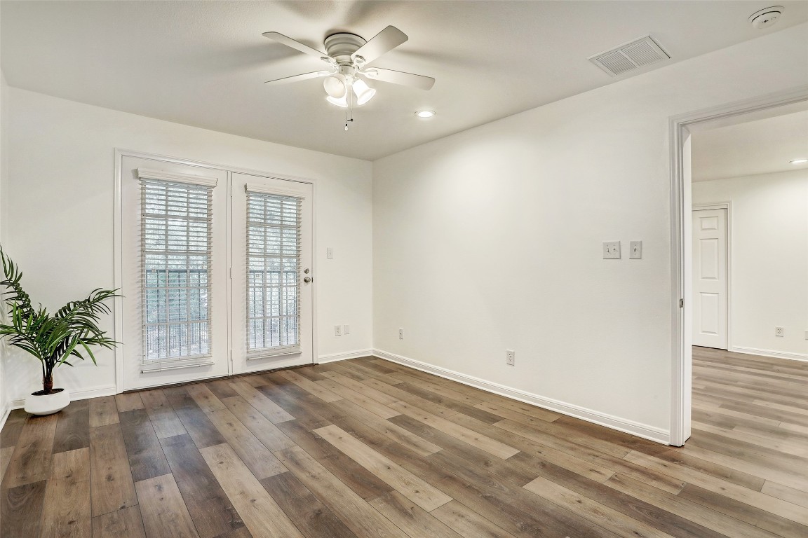 7685 Northcross Drive, Unit 426 Austin, TX 78757 - Photo 16 of 35 an empty room with wooden floor and windows