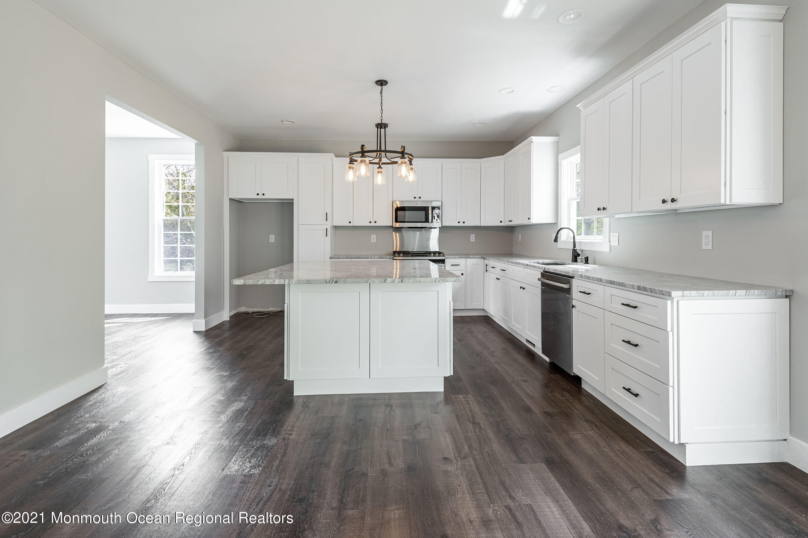 331 East Pleasant Grove Road Jackson, NJ 08527 - Photo 12 of 40 a kitchen with stainless steel appliances kitchen island wooden floors and white cabinets
