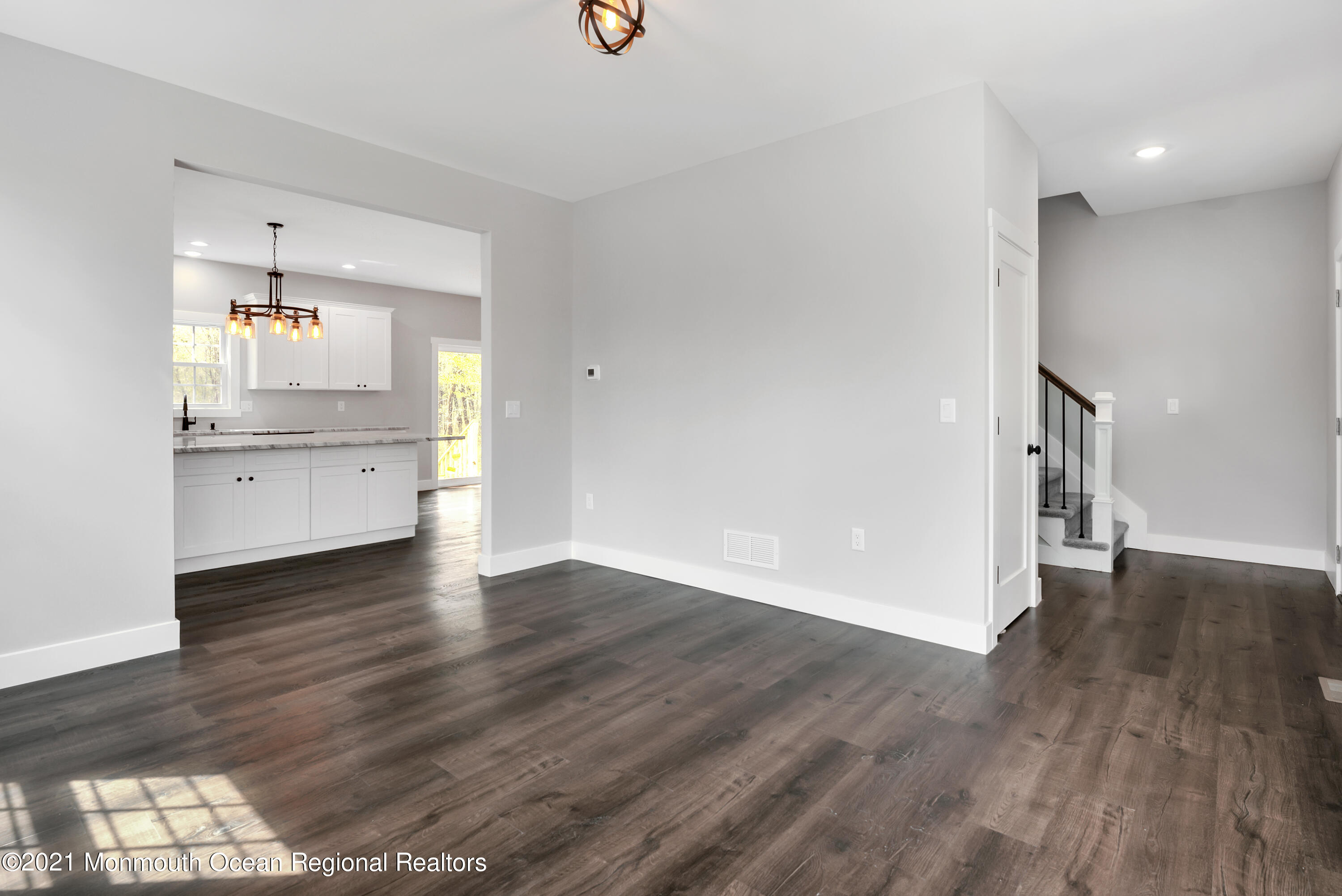 331 East Pleasant Grove Road Jackson, NJ 08527 - Photo 8 of 40 an empty room with wooden floor and a kitchen