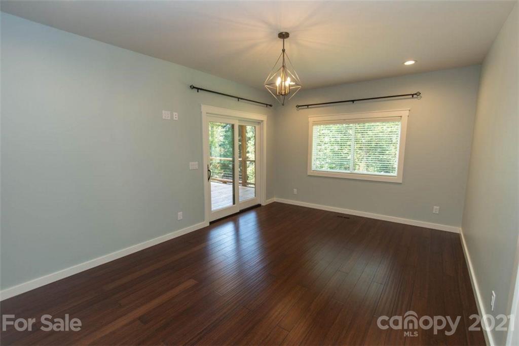 323 Mary Ruth Way Clyde, NC 28721 - Photo 22 of 25 an empty room with wooden floor and windows