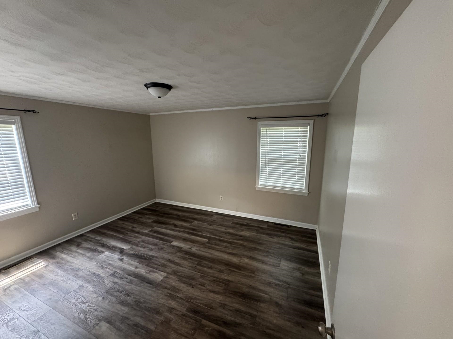 2631 Highway 51 Ripley, TN 38063 - Photo 11 of 17 Spare room with dark wood-type flooring, ornamental molding, and a textured ceiling