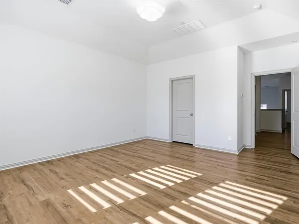 a view of an empty room and wooden floor