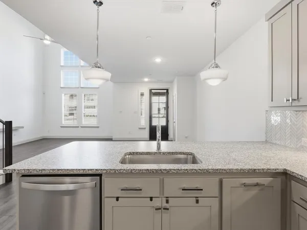 a kitchen with granite countertop a sink a counter space appliances and cabinets