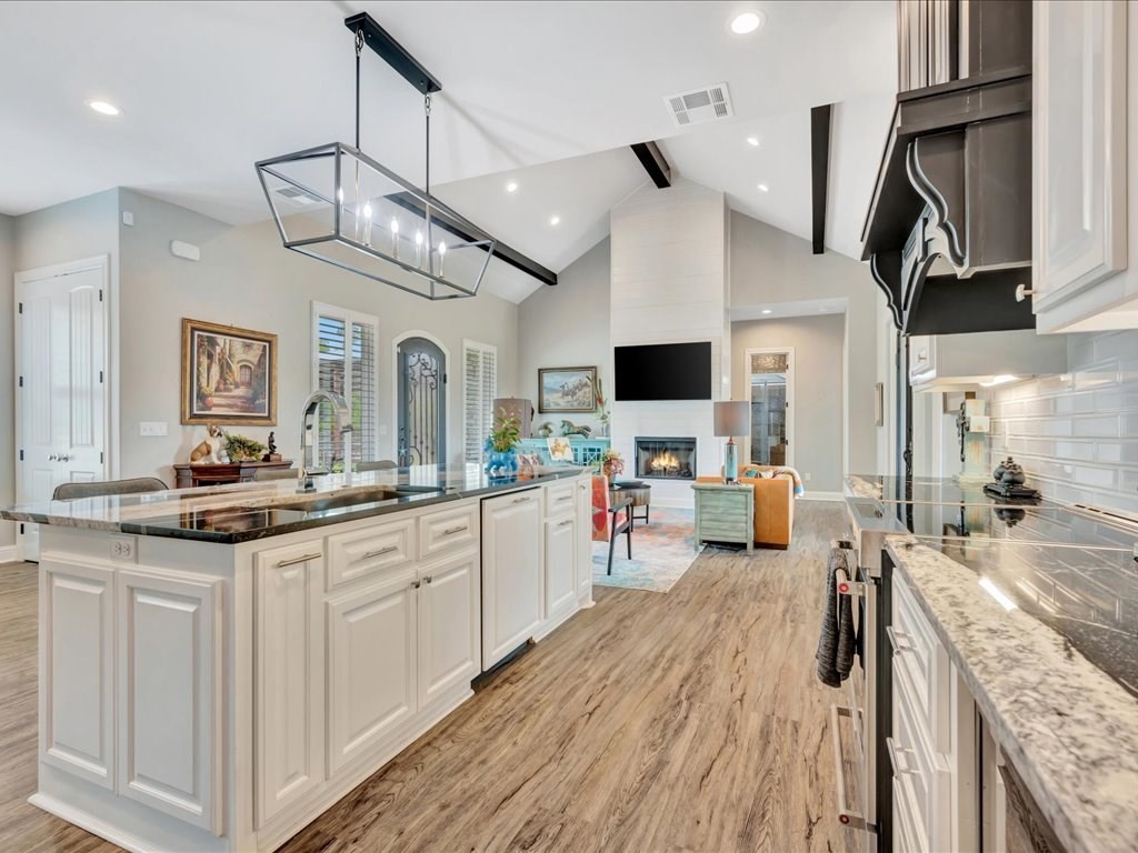 104 Wheeler Road Lufkin, TX 75901 - Photo 16 of 50 a large kitchen with stainless steel appliances kitchen island granite countertop a large stove a sink dishwasher and white cabinets with wooden floor