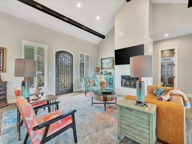 a living room with furniture a flat screen tv and a floor to ceiling window