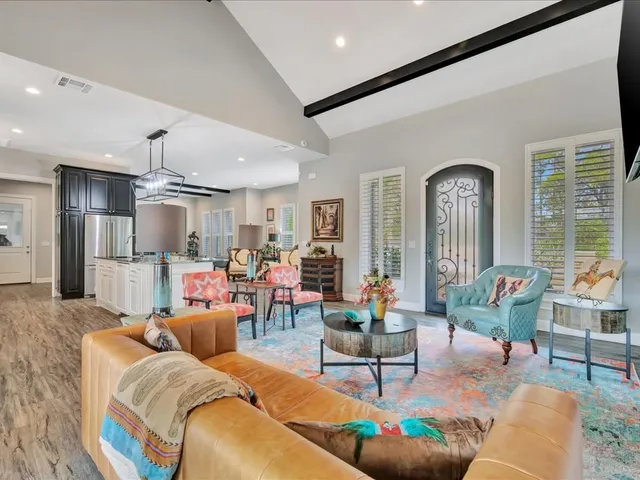 a living room with furniture kitchen view and a large window