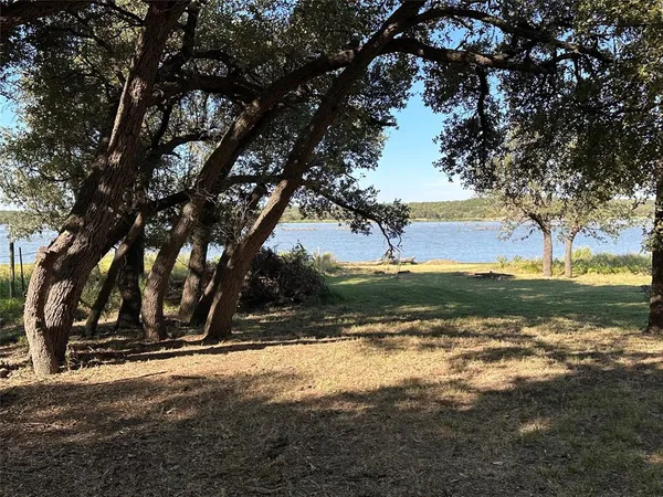 a view of a field with trees around