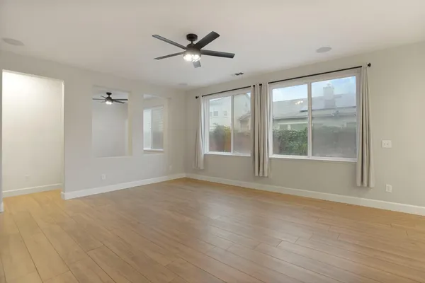 a view of a livingroom with wooden floor and a ceiling fan