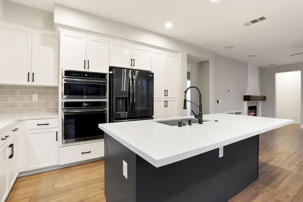 a kitchen with stainless steel appliances granite countertop a sink and a stove top oven