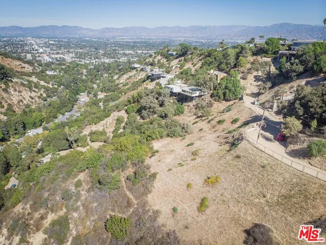 a view of a dry yard with lots of bushes