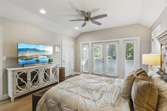 a bedroom with a bed and a flat tv screen on the dresser