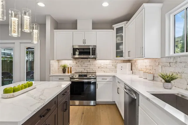 a kitchen with stainless steel appliances a sink a stove top oven a counter space and cabinets