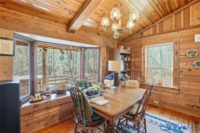 a view of a dining room with furniture large windows and wooden floor