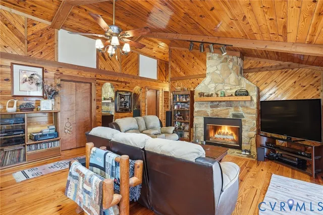 a living room with furniture a flat screen tv and a fireplace