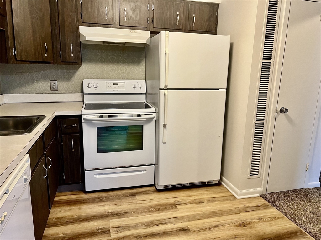 1004 Paradise Road, Unit 1L Swampscott, MA 01907 - Photo 17 of 28 a kitchen with a refrigerator sink and cabinets