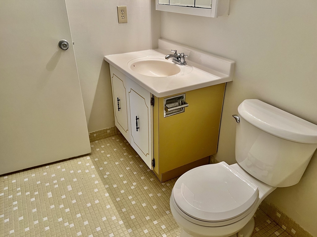 1004 Paradise Road, Unit 1L Swampscott, MA 01907 - Photo 25 of 28 a bathroom with a sink a toilet and a mirror