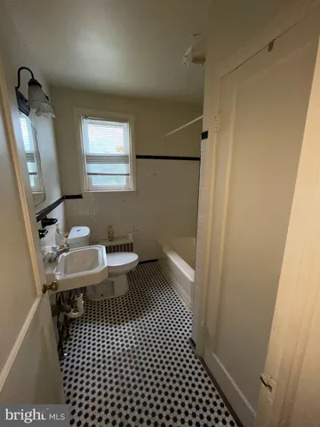 a bathroom with a sink a toilet a mirror and shower