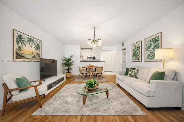 a living room with furniture a flat screen tv and paintings on the wall