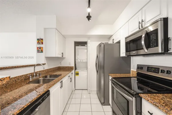 a kitchen with stainless steel appliances granite countertop a stove microwave sink and refrigerator