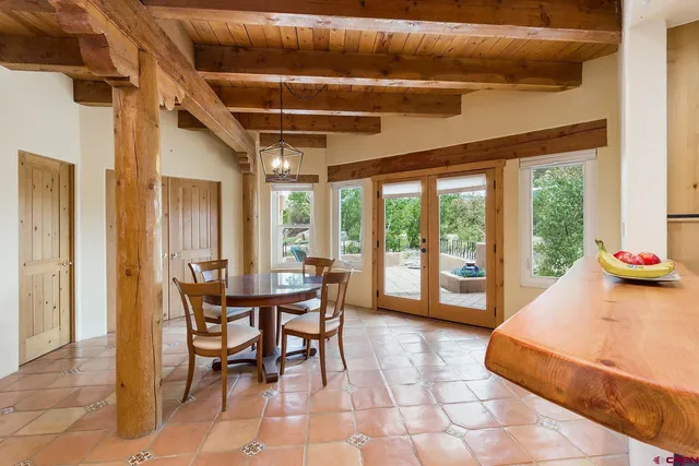 a dining room with furniture and large windows
