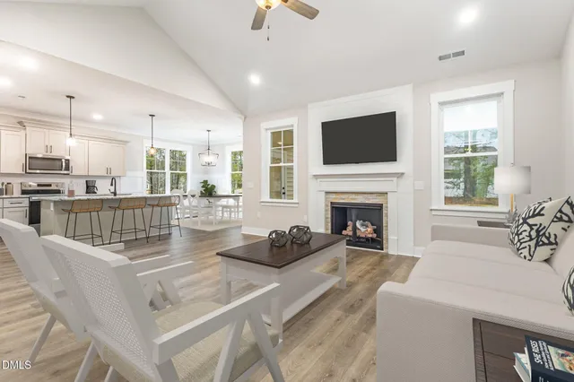 a living room with furniture a flat screen tv and a fireplace