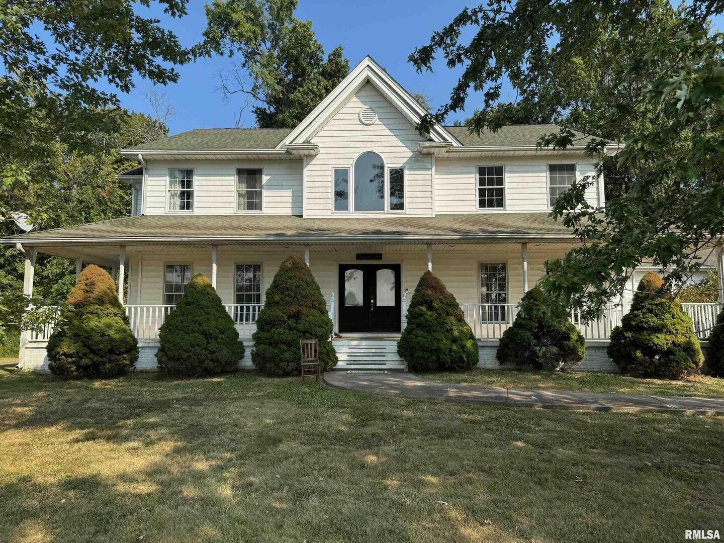 102 West North Street Benton, IL 62812 - Photo 2 of 56 a view of a white house with large windows and a small yard