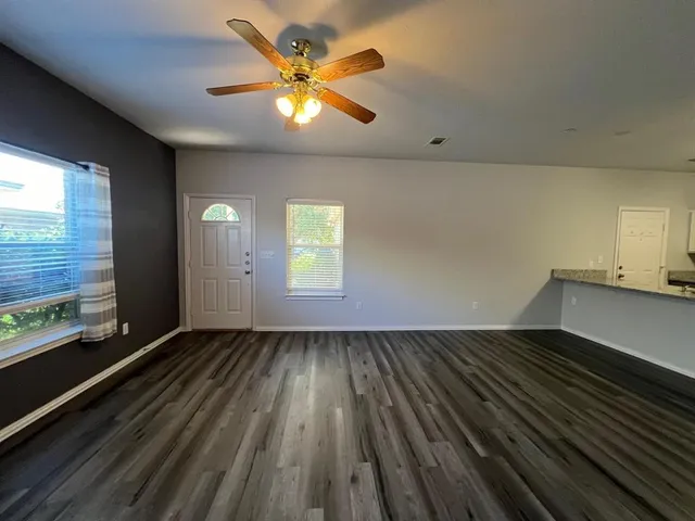 wooden floor in an empty room with a window