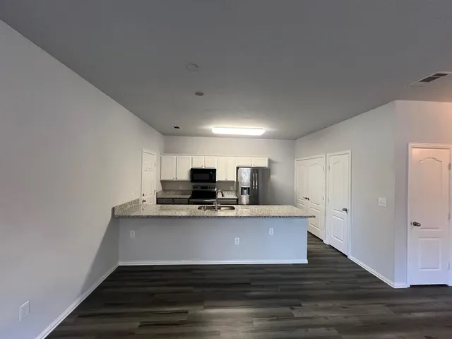 a view of kitchen with microwave stove and refrigerator