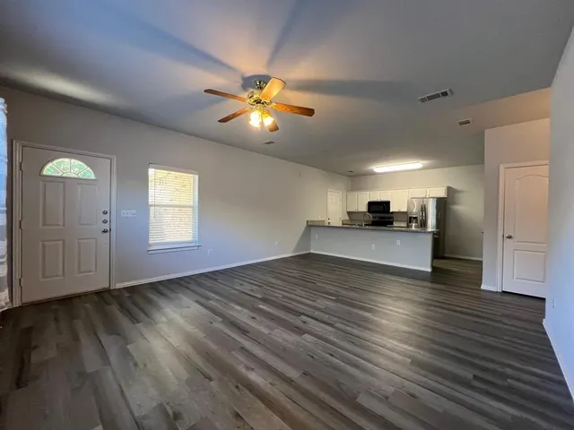 a view of empty room with wooden floor and window