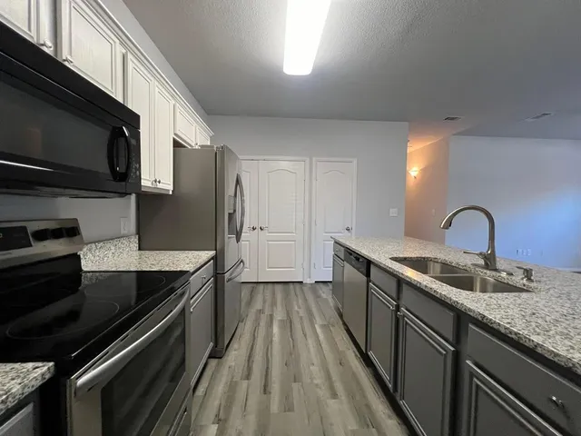 a kitchen with stainless steel appliances granite countertop a sink and stove top oven