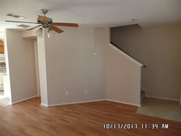 a view of a big room with wooden floor closet and fan