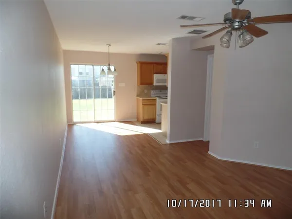 a view of a room with wooden floor fan and windows