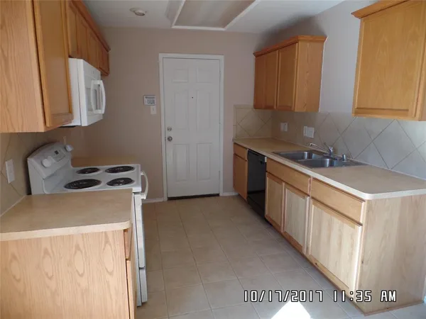 a kitchen with stainless steel appliances a stove a sink a refrigerator and cabinets