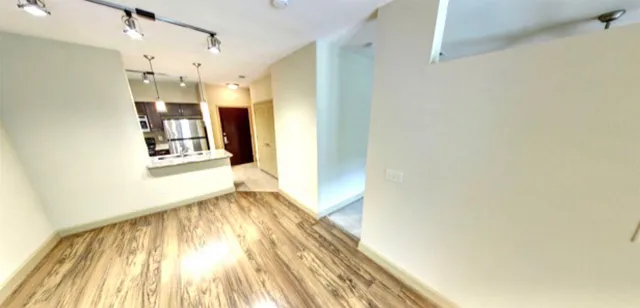 a view of a room with wooden floor and a window